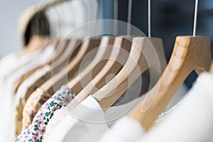 Row of different female clothes hanging on rack in hipster fashion show room in shopping mall. Trendy women wear