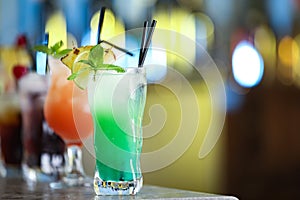 Row of fresh alcoholic cocktails on bar counter