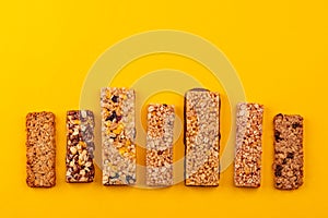 Row of different granola bars on yellow background