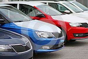 New cars for sale parked in front of a car, motor dealer store, shop