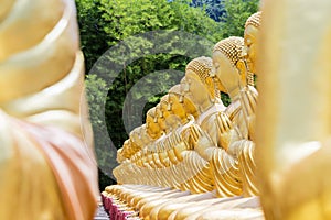Row of disciple statues surrounding big buddha statue in public to the general public worship worship