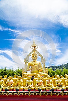 Row of disciple statues surrounding big buddha statue