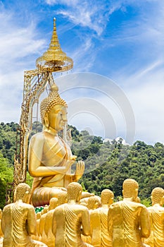 Row of disciple statues surrounding big buddha statue in public to the general public worship worship