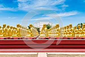 Row of disciple statues surrounding big buddha statue in public to the general public worship worship