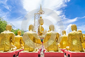 Row of disciple statues surrounding big buddha statue in public to the general public worship worship of, Thailand