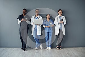 Row, doctors and happy team by wall for interview or public health conference and training session. Technology, medical