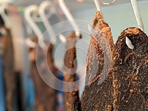 A row of dried beef meat jerky biltong hanging on hooks