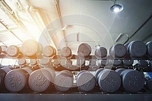 Row of dumbbells in sport club. Exercise in gym for healthy concept.