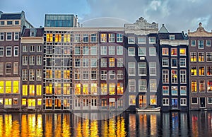 Row of Dutch houses at Central canal Damrak Amsterdam, Netherlands at twilight