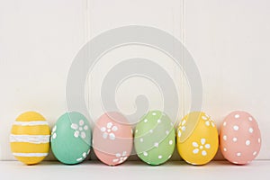 Row of Easter eggs over white wood