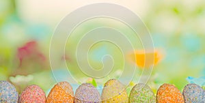 Row Easter eggs with spring green grass background