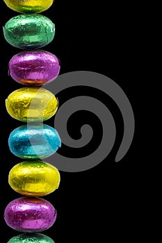 Row of easter egs on a black background. Space for text photo