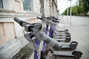 Row of electric scooters parked in the city . Electric urban transportation