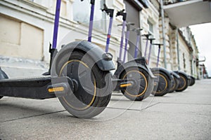 Row of electric scooters parked in the city . Electric urban transportation . Low angle view