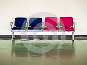 Row empty blue and pink chair in airport for waiting departure area with reflection on floor