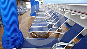 Row of empty deck lounge chairs aboard a cruise ship sailing in the Caribbean