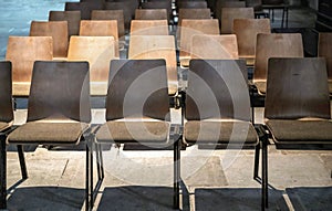 Row of empty wooden chairs in an auditorium