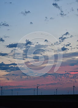 Windmills against a rainbow evening sky