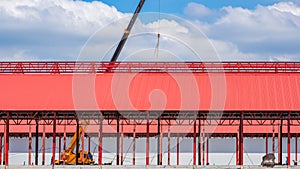 Row of factory building structure with crane truck and construction workers are working in construction site area