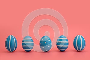 A row of five blue decorated Easter eggs on a pink background.