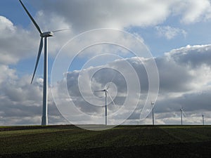 Row of five wind turbines in a field in France