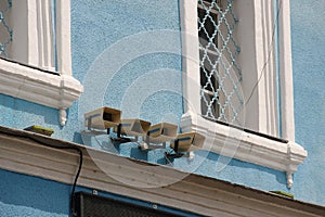 Row of four loudspeakers on blue plastered wal