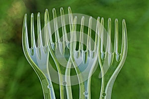 A row of four transparent white plastic forks