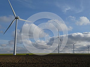 Row of four wind turbines in a field in France, Europe