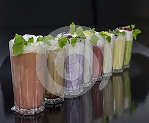 Row of fresh milk cocktails with fruits and berries