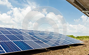 Row of front side view photovoltaic solar panels / modules at solar power station