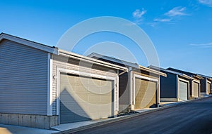 Row of garage doors at parking area for townhouses. New garages in alley. New Alley Construction