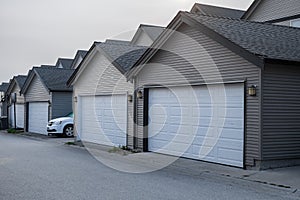 Row of garage doors at parking area for townhouses. Private garages for storage or cars in rows in an alley