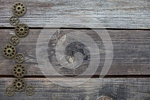 Row of gears on a wooden background