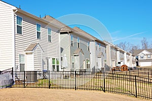 Row of generic houses from backyard view in a southeast U.S. suburb on a beautiful blue sky day