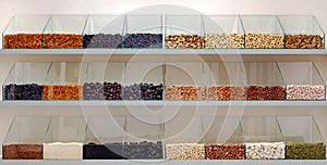 A row of glass containers filled with various types of nuts and seeds