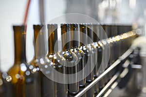 Row of glass wine bottles moving by conveyor