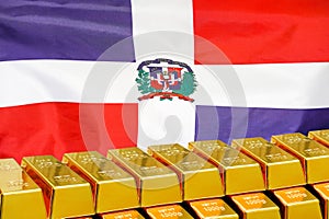 Row of gold bars on the Dominican Republic flag background. Concept of gold reserve and gold fund of Dominican Republic