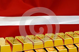 Row of gold bars on the Latvia flag background. Concept of gold reserve and gold fund of Latvia