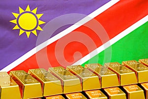 Row of gold bars on the Namibia flag background. Concept of gold reserve and gold fund of Namibia