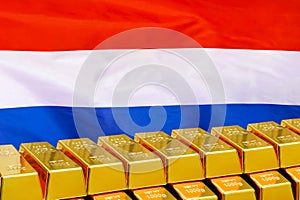 Row of gold bars on the Netherlands flag background. Concept of gold reserve and gold fund of Netherlands