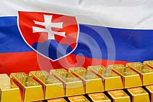 Row of gold bars on the Slovakia flag background. Concept of gold reserve and gold fund of Slovakia