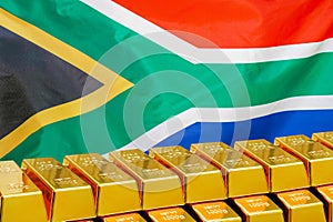 Row of gold bars on the South Africa flag background. Concept of gold reserve and gold fund of South Africa