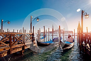 Row of gondola boats parked outside restaurant Grand Canal in Venice, Italy.