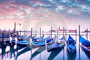 Row of gondolas parked on city pier