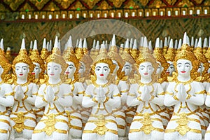 Row of gorgeous angel statue groups sitting and press the hands together at the chest in temple