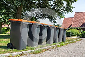 Row of gray waste containers along the street
