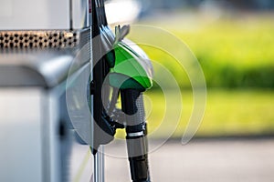 Row with green and black refueling guns at the gas station, close-up, horizontal shot