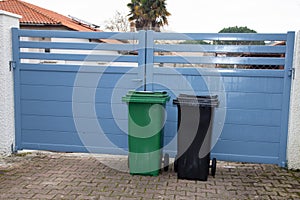 Row of Green grey plastic dust recycling bin in street front house