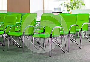 row of green office chairs in office. Selective focus