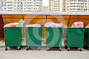 Row of green overfill garbage bins in residential, front view